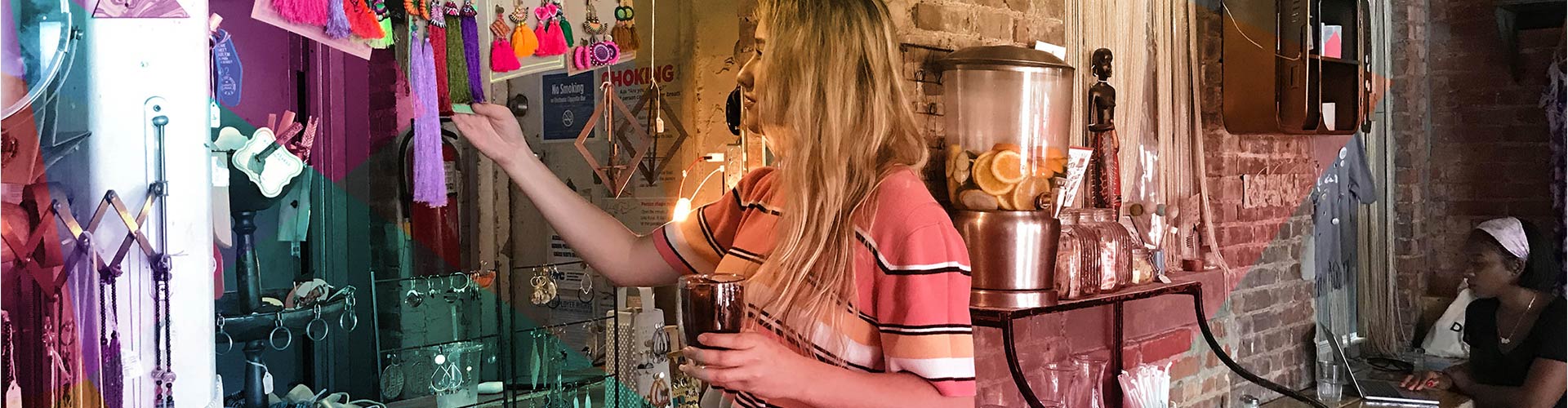 Blog banner featuring woman holding drink while looking at store jewelry