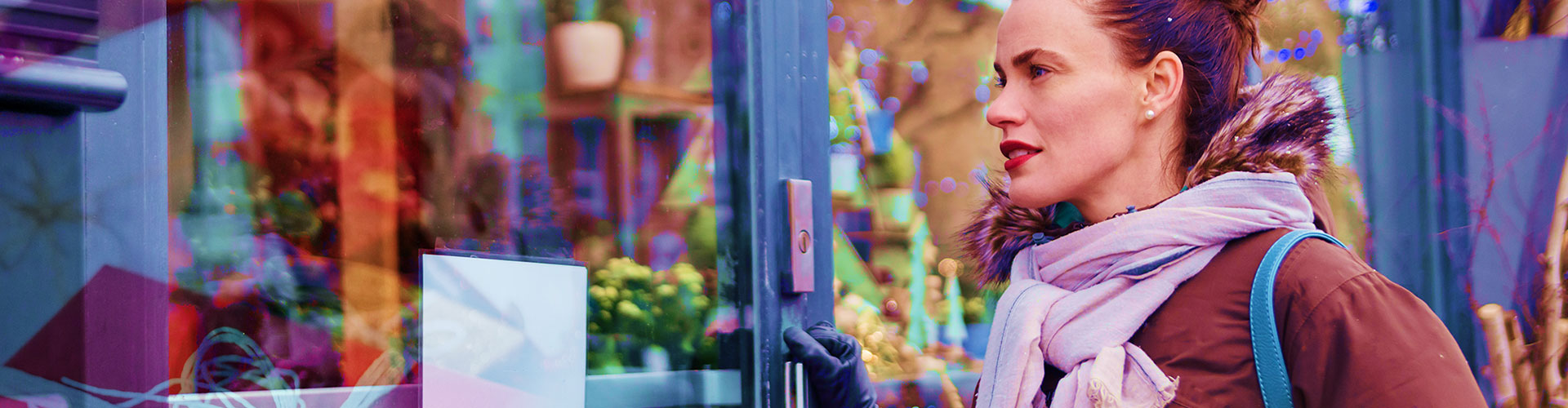 Retailers are Hiring for the Holidays, but for the Store? blog banner featuring woman in winter clothes standing at a door of storefront