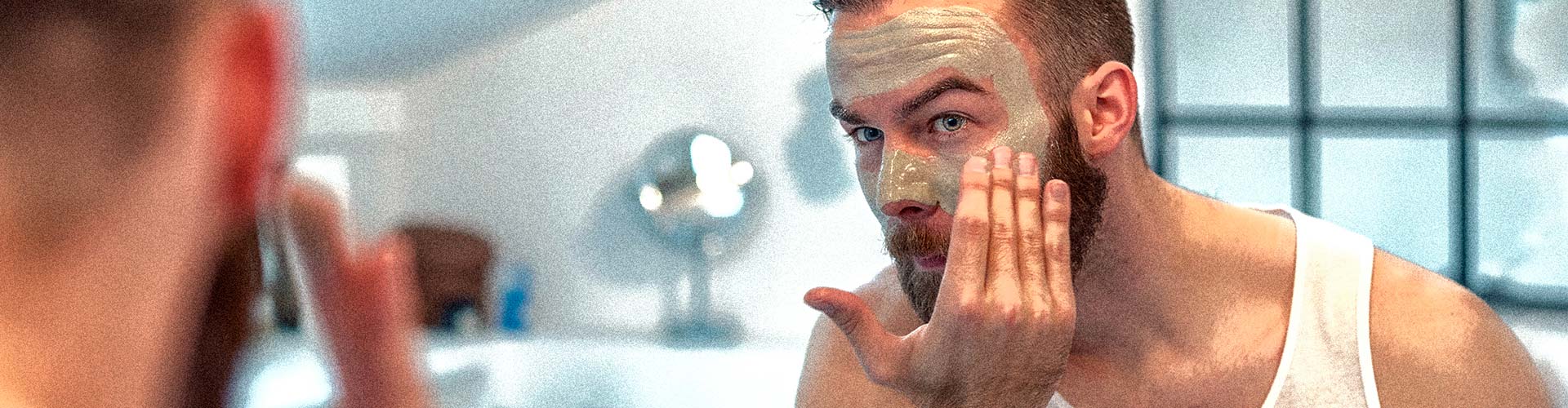 3 Ways to Know if Your Beauty Brands are Man Enough blog banner featuring man putting spreadable face mask product on in bathroom mirror
