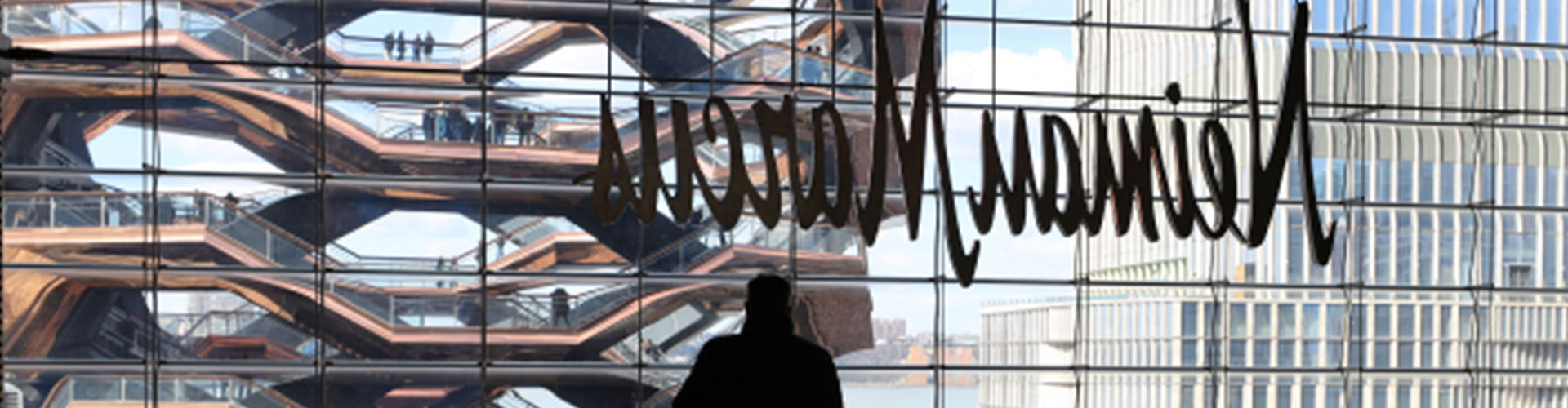 Post Neiman’s, Luxe Beauty Brands Explore Options blog banner featuring person leaning against rail and looking out window of Nieman Marcus store