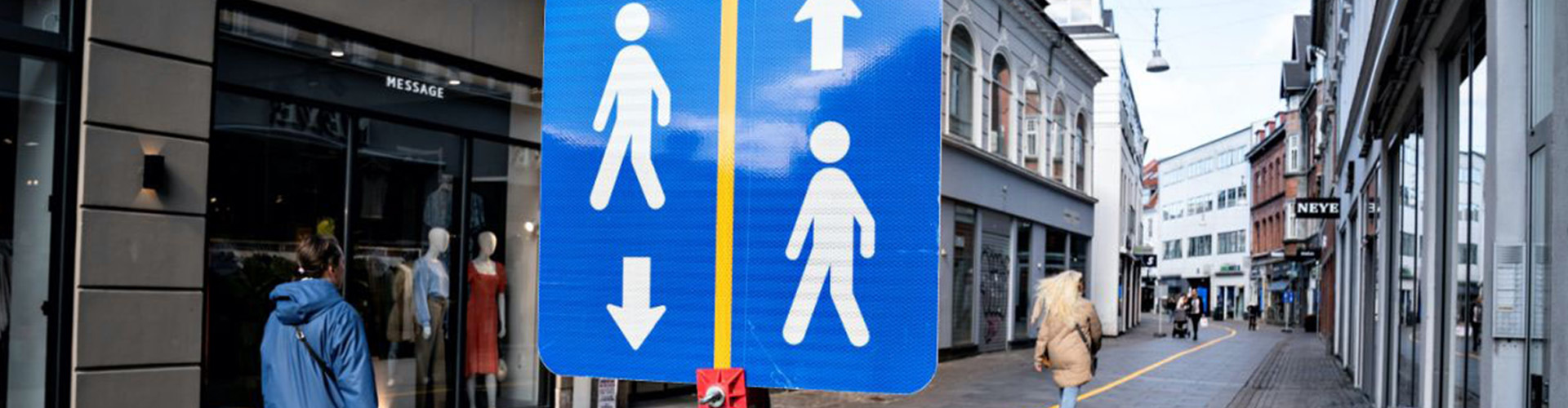 The Bridge to an Open Society Report Banner featuring people walking on the street with a sign depicting walking icons going opposite directions