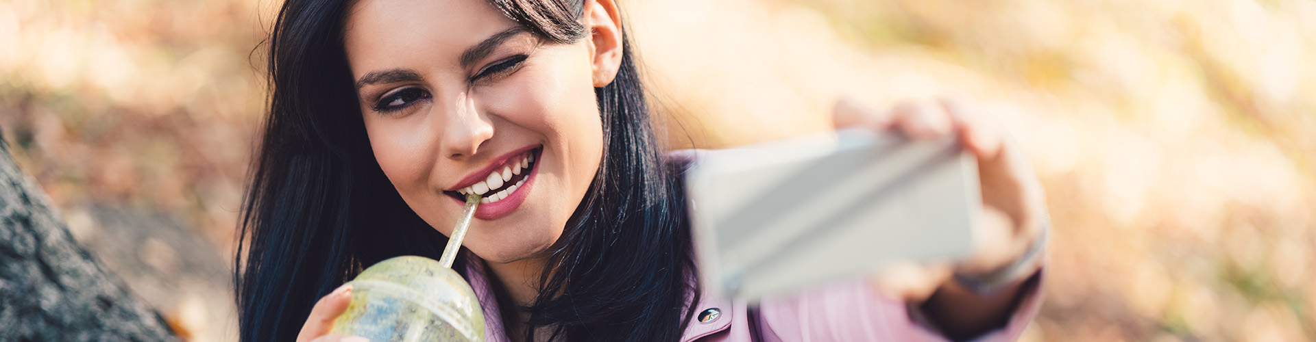 Gen Z Changes How You Need to Deliver WELLness Report Banner featuring Gen Z Woman taking selfie with drink in hand